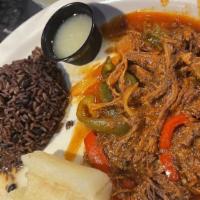 Ropa Vieja · Shredded beef cooked in tomato sauce, with red and green peppers and onion. Served with frie...