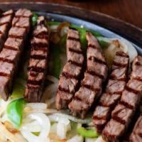 Flaming Fajitas · sizzling strips grilled to perfections with bell peppers and onions, Served with guacamole, ...