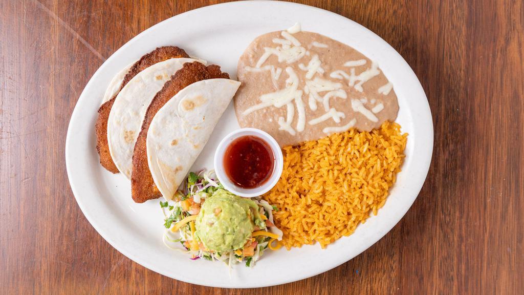 Tacos Al Carbon · two flour tortillas filled with strips of charbroiled steak, fresh pico de Gallo. Served with guacamole, sour cream, rice, and refried beans.