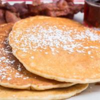 Pancakes · Three buttermilk golden cakes. Served with bacon or sausage & finished with powdered sugar. ...