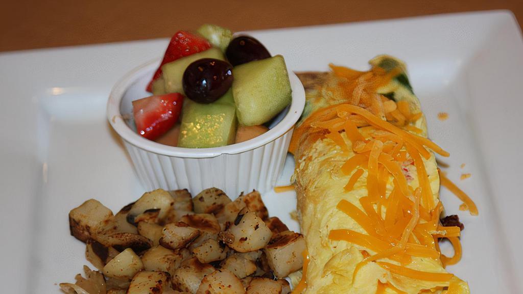 Vegetable Omelet · Three egg omelet with onions, tomatoes, mushrooms, bell peppers and cheddar cheese. Served with choice of bread or biscuit & gravy & potatoes or fresh fruit.