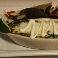 Southwestern Spinach Dip · Four cheese blend, spinach and southwestern spices. Topped with sour cream and served with c...
