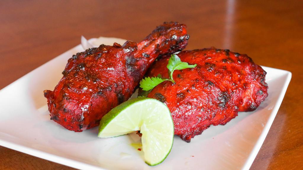 Tandoori Chicken (Full) · Tender bone-in chicken, marinated with exotic tandoori spices, roasted in clay oven, served with mint chutney and onion salad.