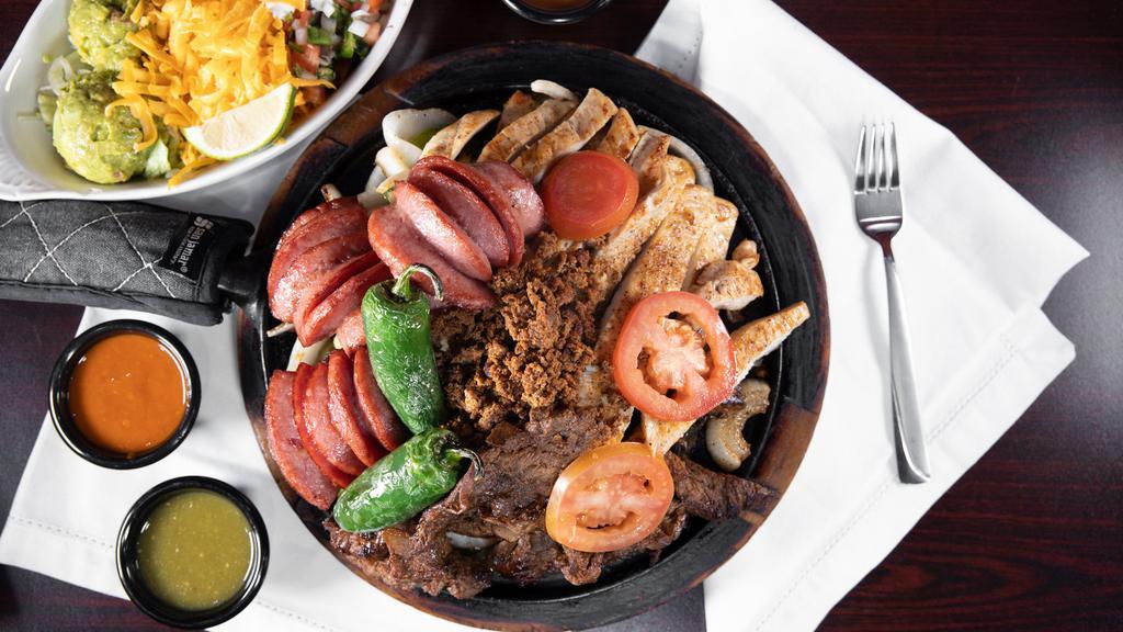 4 Different Meats · Fajita, pollo, chorizo, and salchichon. Grilled onions, bell peppers, grilled peppers, lemon, sour cream, guacamole. Served with 3 plates of rice and beans. And your choice of corn or flour tortillas. Substitute meat for an additional charge.