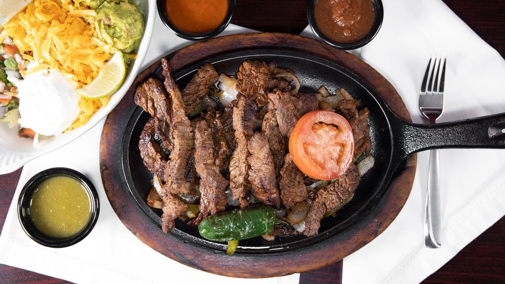 Fajitas Asadas · Charbroiled beef fajita grilled with onions, bells peppers, grilled peppers. Served with rice, beans, salad guacamole and sour cream.