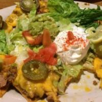 Mexicali Nachos · With beef or chicken, beans, cheese, guacamole, sour cream, lettuce, tomatoes and jalapeno p...
