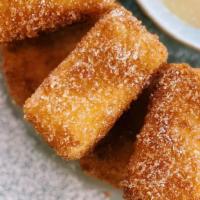 Fried Mylk · Panko crusted fried milk pudding with  powdered sugar and condensed milk.