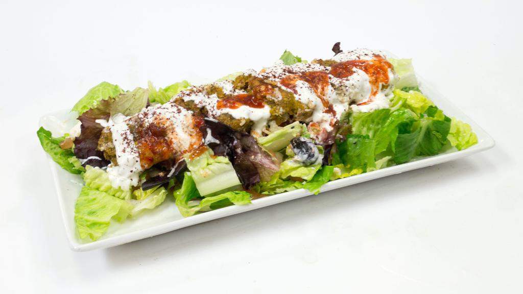 Falafel Salad · Grilled Falafel over a bed of greek salad, house dressing, yogurt sauce, cilantro sauce, and seasonings!