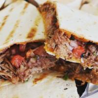 Shaved Brisket Quesadilla · Smoked shaved brisket, shredded cheddar, drizzle of blueberry sauce, pico de gallo on a flou...