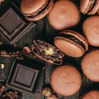 Chocolate Coconut Macaron · A chocolate & toasted coconut macaron shell sandwiched together with a chocolate cream filli...