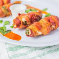 Bacon Wrapped Jalapenos · Chorizo and cheese stuffed inside jalapenos wrapped in bacon and deep fried.