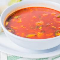 Menudo · A traditional Mexican soup made with beef tripe and hominy beans in broth with red chili pep...