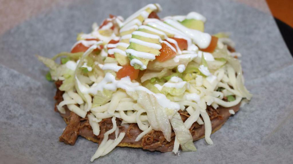 Tostada · Prepared with your choice of meat, beans, cilantro, onions, cheese, lettuce, avocado, tomatoes, and sour cream.