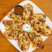 Brisket Chips · Hand cut potato chips topped with smoked brisket, smothered in queso and green onions.