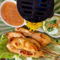 Chicken Satay · Marinated chicken on a stick serves with peanut sauce and cucumber salad.