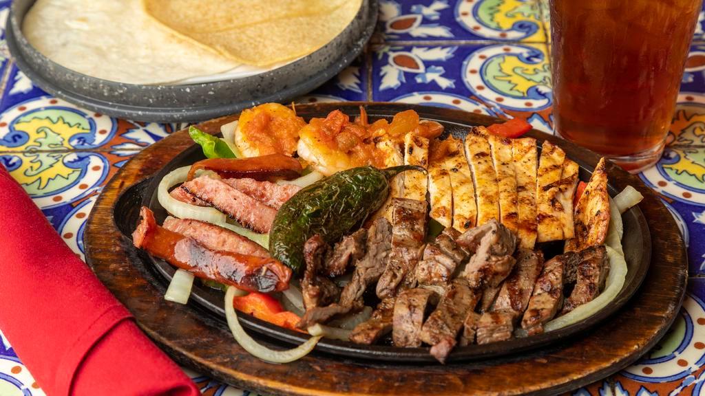 La Parillada · Beef, chicken, shrimp and sausage with grilled peppers and onions, served with charro beans, rice, guacamole, sour cream, pico de gallo and a grilled jalapeño.
