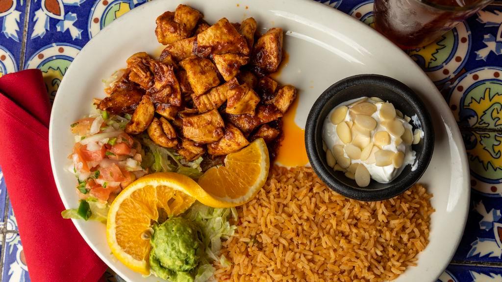 Long Horn Special Pollo Adobado · Tender chunks of chicken sautéed in chile ancho sauce served with rice, guacamole, and sour cream topped with almonds.