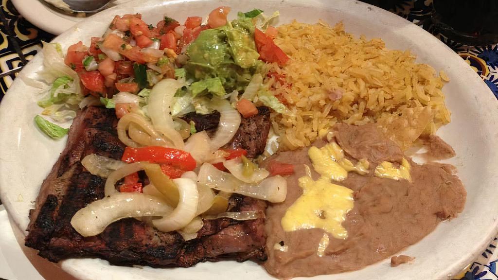 Carne Asada · A marinated beef skirt steak, grilled and specially seasoned served with charro bean soup rice, guacamole, sour cream and pico de gallo.