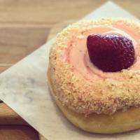 Strawberry Cheesecake · A raised donut frosted with strawberry flavored cheesecake with cake crumbs and topped with ...