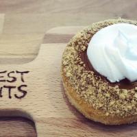 Caffe Latte Donut · A soft raised donut loaded with house-made coffee flavored icing and graham cracker crumbs, ...