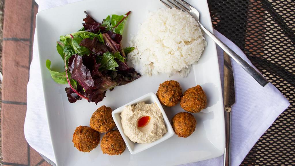The Falafel Bombs · Classic chickpea balls with special seasoning, with rice, half pita and organic spring mix, pickled red cabbage, sweet corn, olive oil lemon dressing.