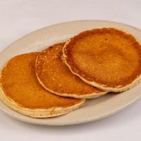 Buttermilk Pancakes · Three buttermilk pancakes with hot syrup.