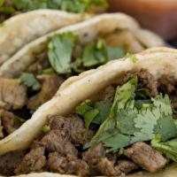 Mini Tacos · Five corn tortillas filled with marinated skirt steak topped with cilantro, onions, and lime.