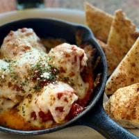 Baked Meatballs · Topped with Homemade Marinara, Melted Mozzarella and Homemade Bread.