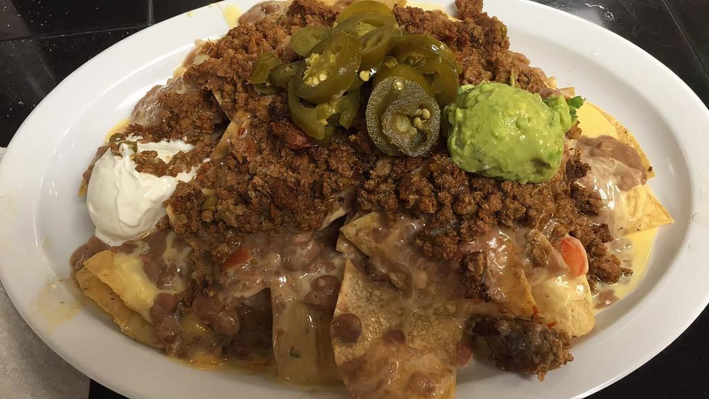 Nachos Supreme · Your choice of chicken or beef with refried beans and cheese. Served with sour cream, guacamole, and jalapeños.