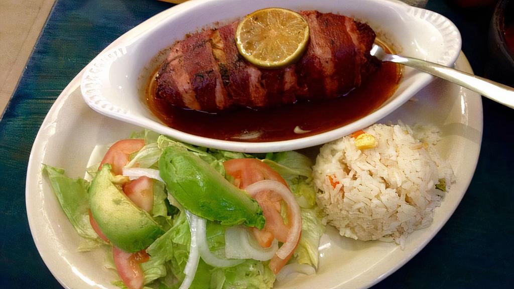 Filete Relleno A La Plancha · Tilapia fillet filled with octopus and shrimp, wrapped with bacon, topped with a butter parsley dressing. Served with rice and mix salad.