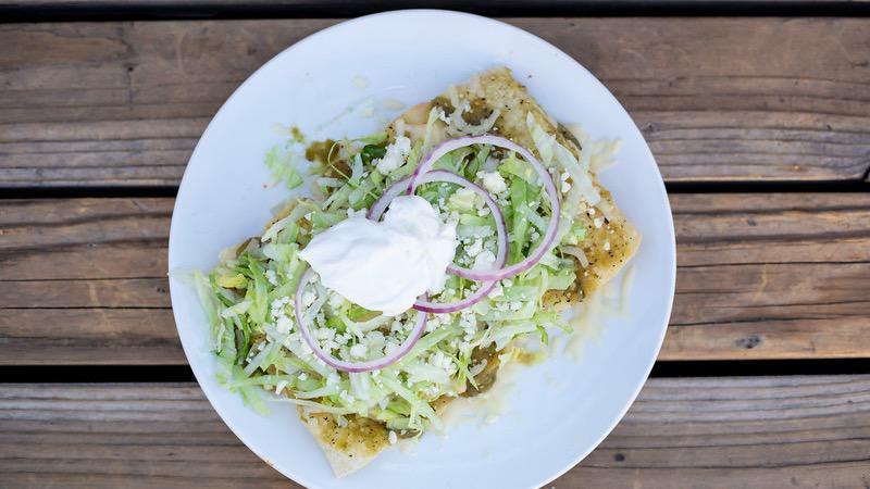 Enchiladas Verdes · Choice of steak, shredded chicken or cheese, topped with a spicy green tomatillo salsa verde, lettuce, crema Oaxaca, and queso cotija, served with rice and beans