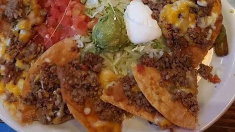 Chicken Nachos De Fajita · Individual corn tortilla chips topped with beans, chicken fajitas with cheese. Served with sour cream, guacamole, jalapenos, lettuce and tomatoes.