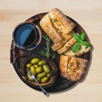 Uptown Greek Bread · homemade basil pesto, tomatoes, olive oil, feta, and mozzarella.