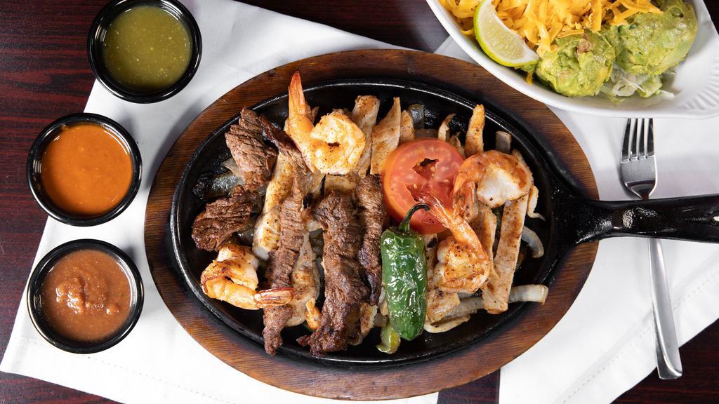 Parrilada Sonora · A combination plate with chicken, beef, and shrimp marinated and grilled, sautéed with onions, bell peppers served with rice, beans, pico de gallo, guacamole, sour cream, and cheddar cheese.