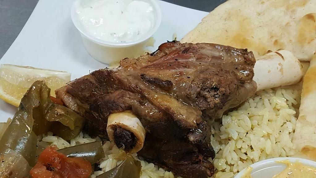 Lamb Shank Plate. · Oven roasted Lamb Shank served with rice small salad tzatziki and pita bread!