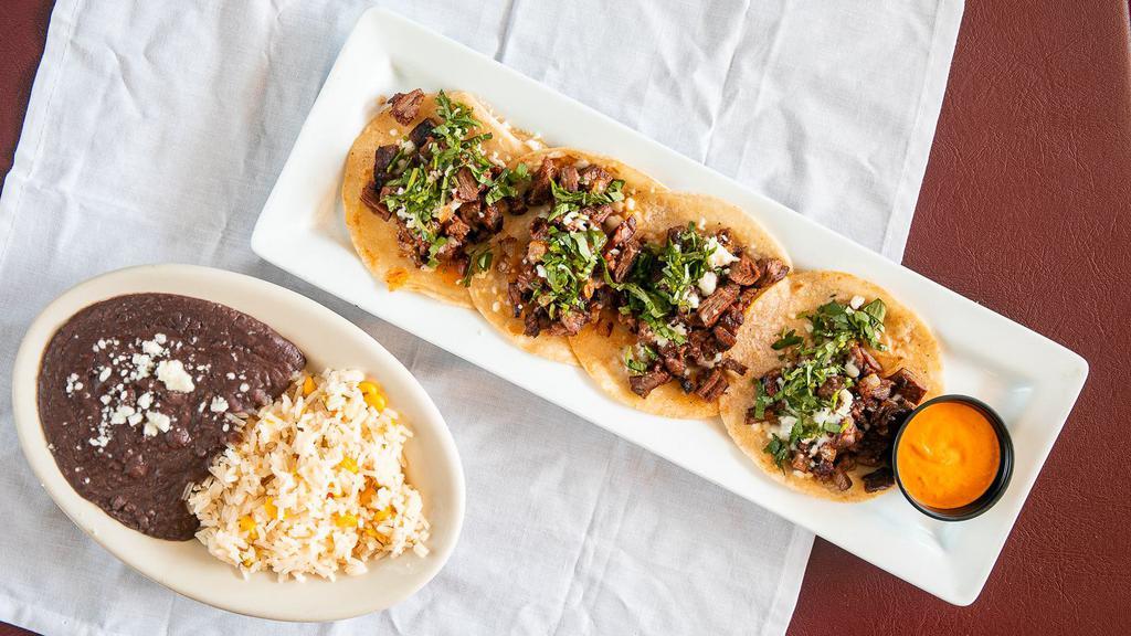 Tacos Del Pueblo · Chopped fajita beef, onions, jalapeños, and cilantro y queso fresco on a corn tortilla. Served with rice and black beans.