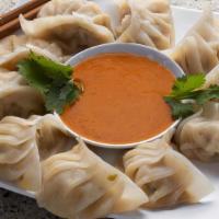 Juicy Pork (Steamed) · Handcrafted pork momo served steamed with homemade tomato dipping sauce.