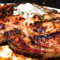 Bone-In Ribeye · Grilled bone-in 20 ounce ribeye steak topped with garlic butter.