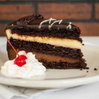 Chocolate Mousse Cake · Layers of dark, white, and milk chocolate mousse between moist cake and covered with chocola...