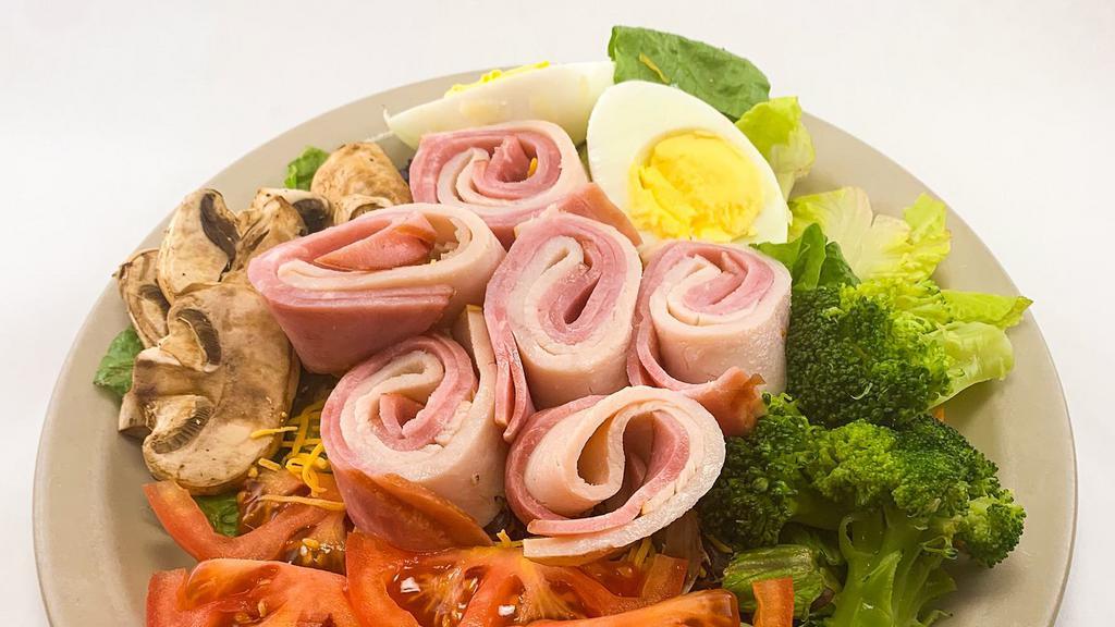 Chef Salad · Mixed greens with tomatoes, broccoli, mushrooms, a hard boiled egg, and cheese, topped with Ham and Turkey