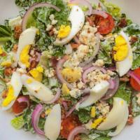 Cobb Salad · Leafy romaine, cherry tomatoes, red onion, crispy bacon, hard-boiled egg, bleu cheese crumbl...