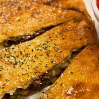 Cheesesteak Calzone · Thinly sliced beefsteak with mozzarella cheese, green bell peppers, and sauteed onions