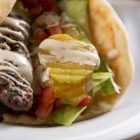 Lamb Kabob Wrap · Lamb wrapped in pita bread with lettuce, tomatoes, hummus & pickles.