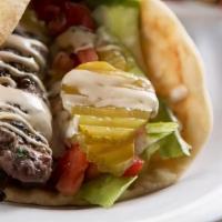 Lamb Wrap · lamb kabob wrapped in pita bread with lettuce, tomatoes, hummus & pickles.