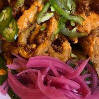 Calamares · Golden-fried calamari topped with chorizo, pickled onions, shaved jalapeños, grilled lime, a...