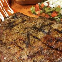 Carne Tampiqueña · Our signature Steak Certified Angus Beef, guacamole, refried black beans. Served with a red ...