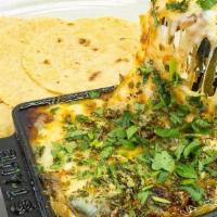Queso Fundido · melted queso menonita, muenster enchilado, shredded oaxaca cheese, grilled onions, roasted p...