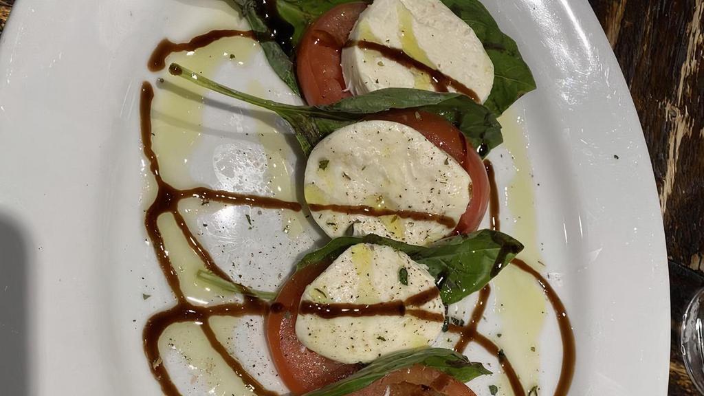 Insalata Caprese · Perfectly ripened Roma tomatoes, house-made mozzarella, and garden-fresh basil, drizzled with balsamic glaze and Sicilian extra virgin olive oil.