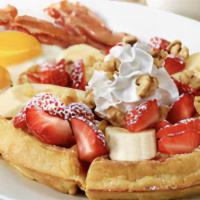 Strawbry Banana Waffle Combo · A golden Belgian waffle topped with fresh strawberries, bananas and toasted walnuts. Served ...