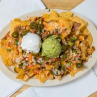 Loaded Nachos · Fresh made and covering a full plate. Topped in meat, beans, cheese, served with guacamole a...